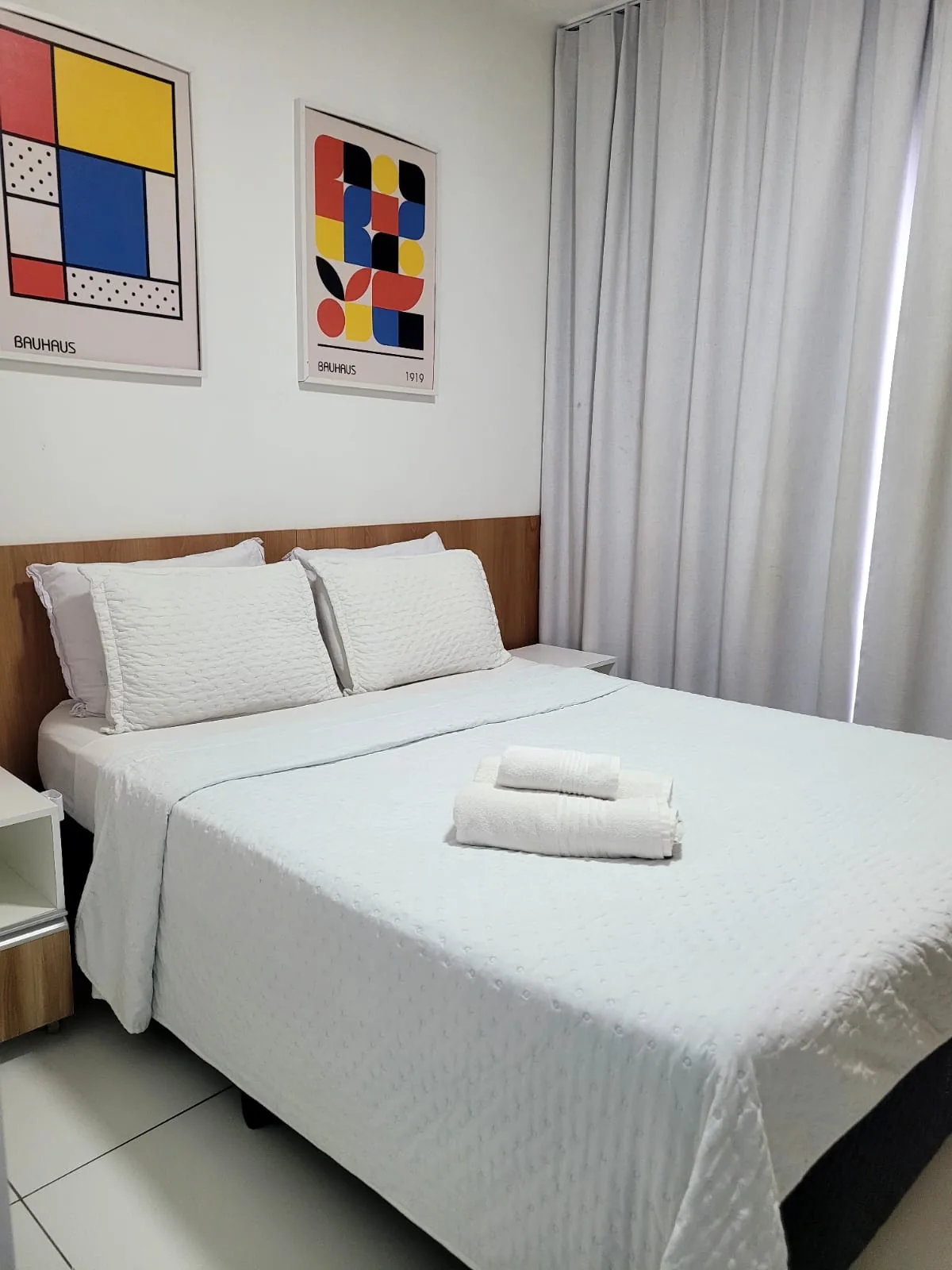 Quarto com cama de casal e quadros