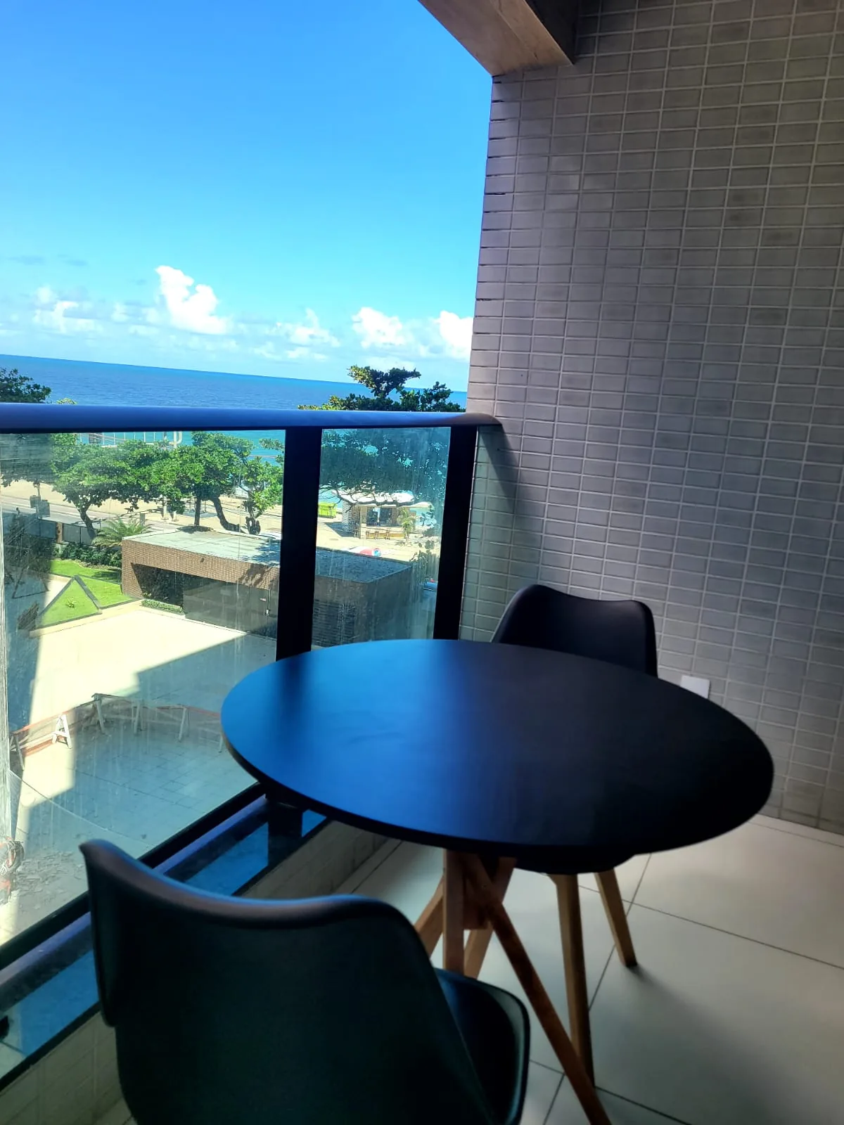 Varanda com mesa e vista para o mar