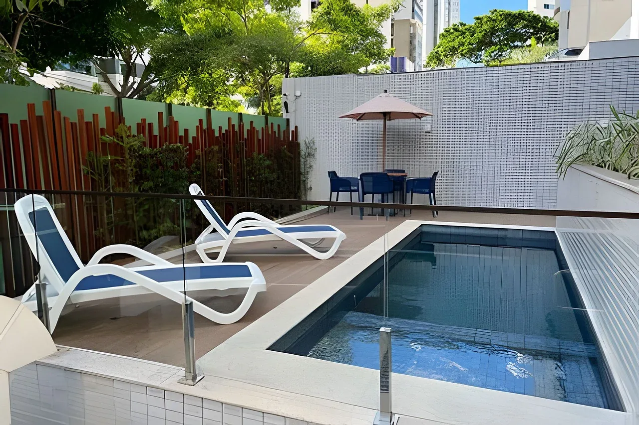 Piscina com espreguiçadeiras e jardim